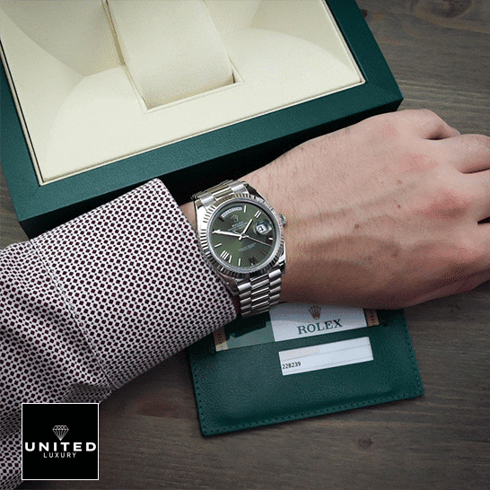 Rolex Day-Date Olive Green 228239  Rolex Box in front of on is arm