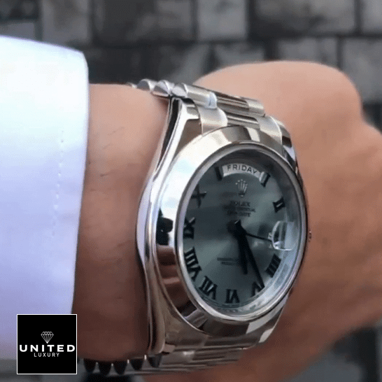the man has a Rolex Day-Date II Stainless Steel Ice Blue Roman Dial 218206 